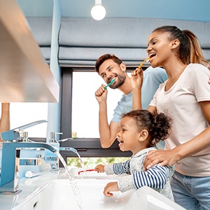 Family brushing teeth at kitchen sink