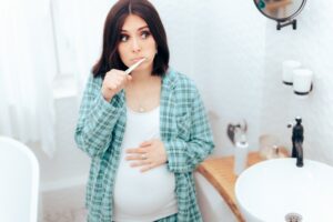 Pregnant woman brushing her teeth